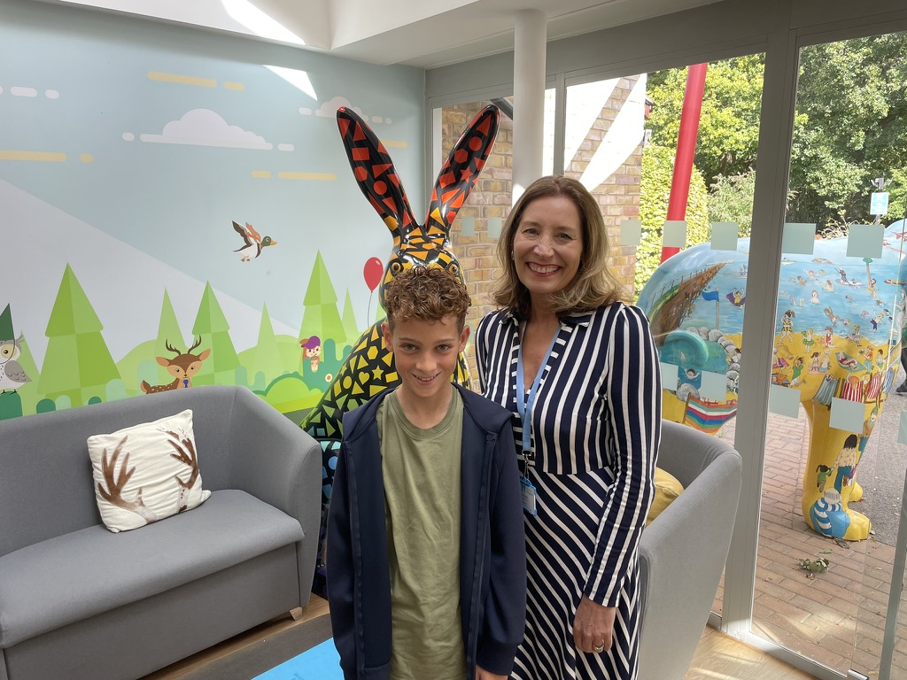 Dexter standing in the hospice lobby beside the painted rabbit and elephant sculptures