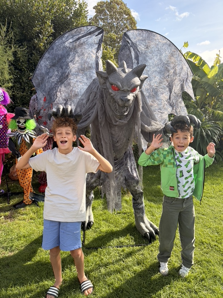 Two boys posing either side of the large winged gargoyle