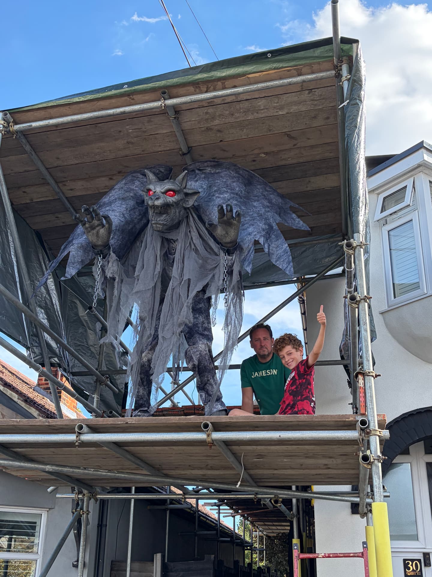 Dexter giving a thumbs up on the platform beside the gargoyle