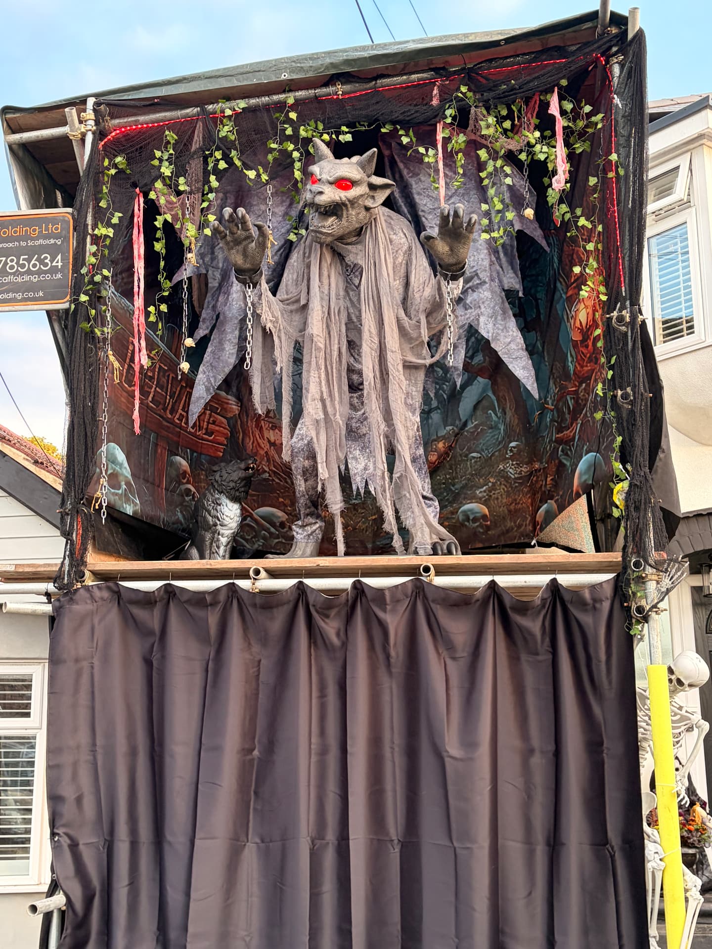 The decorated gargoyle, with glowing red eyes, chains and hanging vines